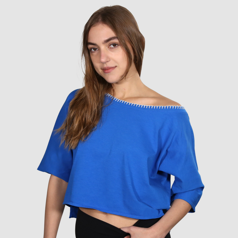 Woman wearing a blue wide neck nautical themed T Shirt on a white background