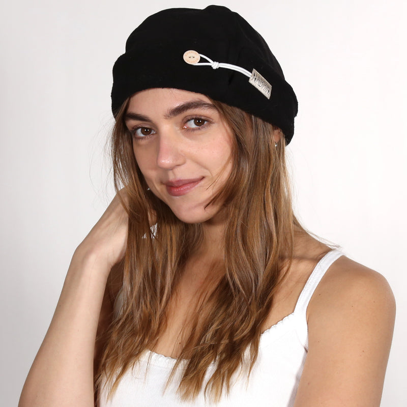 Close up of a black nautical themed beanie on a white background