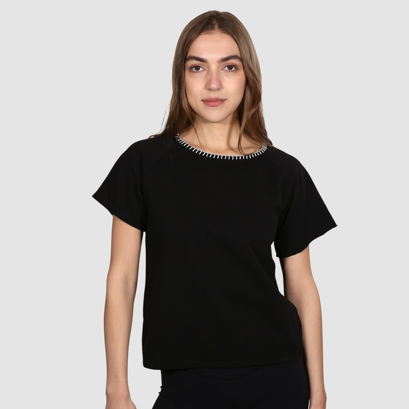 Woman wearing a black nautical themed crew neck T Shirt on a white background