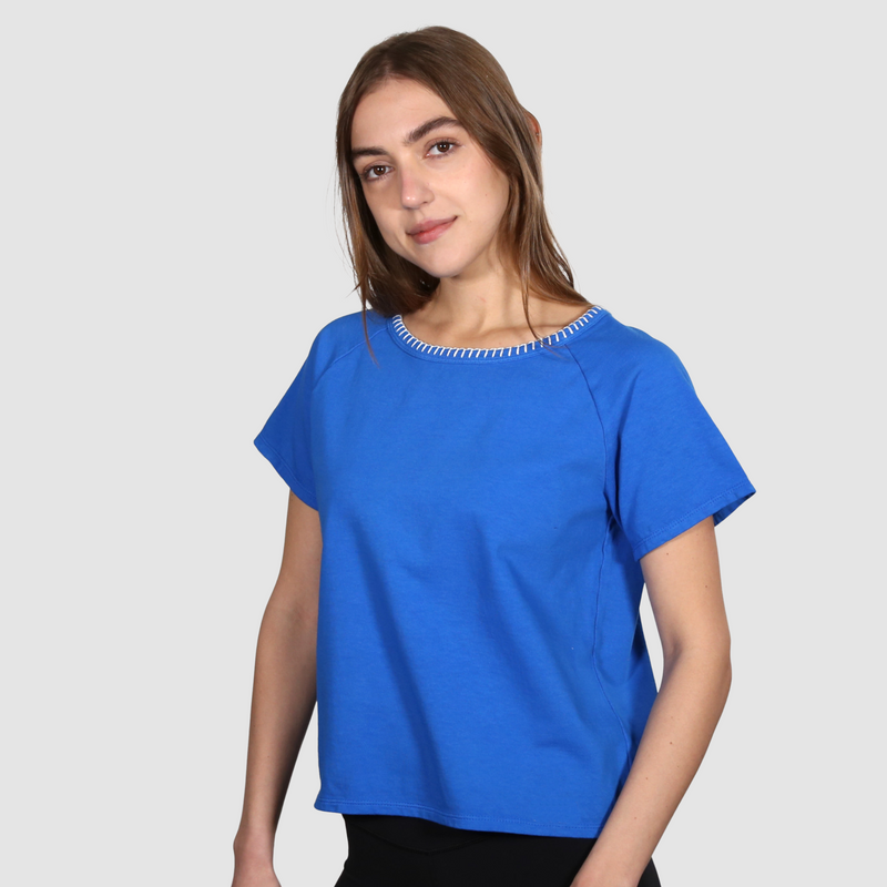 Woman wearing a blue nautical themed crew neck T shirt on a white background
