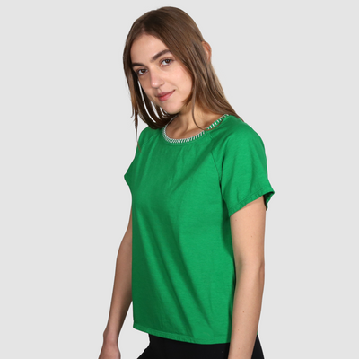 Woman wearing a green nautical themed crew neck T Shirt on a white background