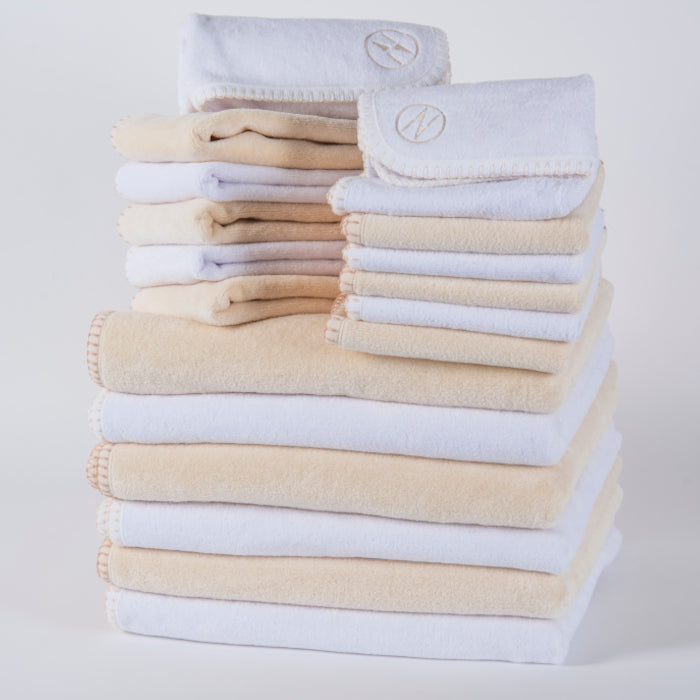 A large stack of alternating colored white and champagne nautical themed towels