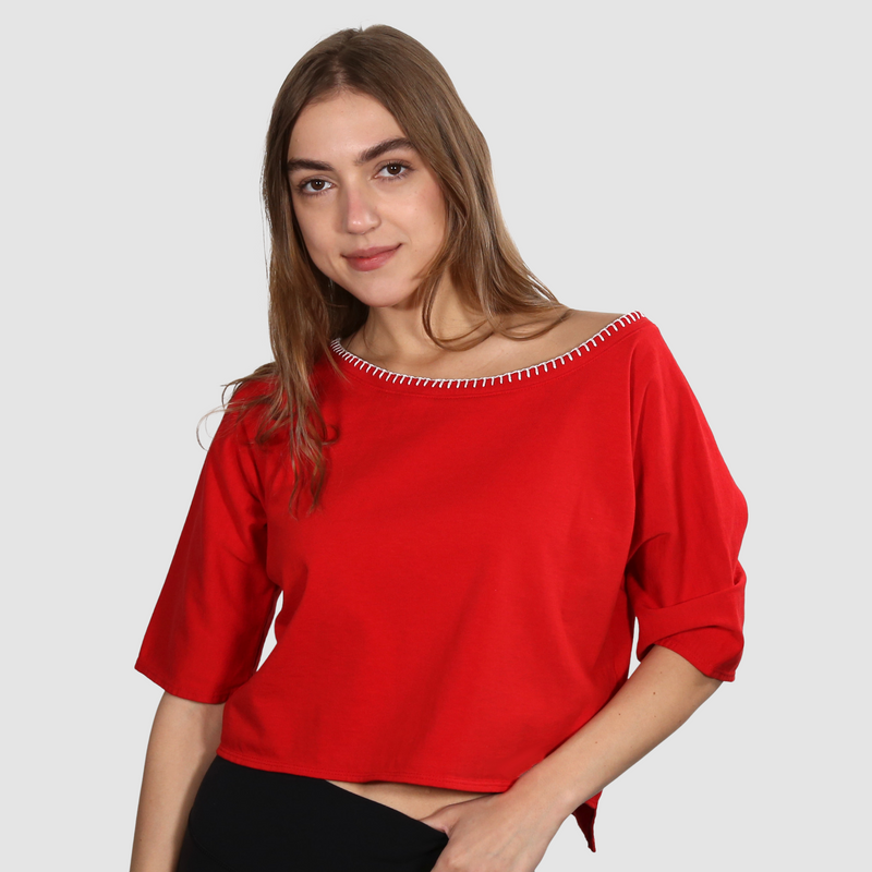 Woman wearing a red nautical themed wide neck T Shirt on a white background