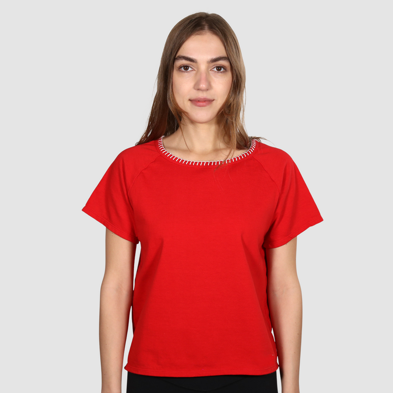 Woman wearing a red nautical themed crew neck T Shirt on a white background