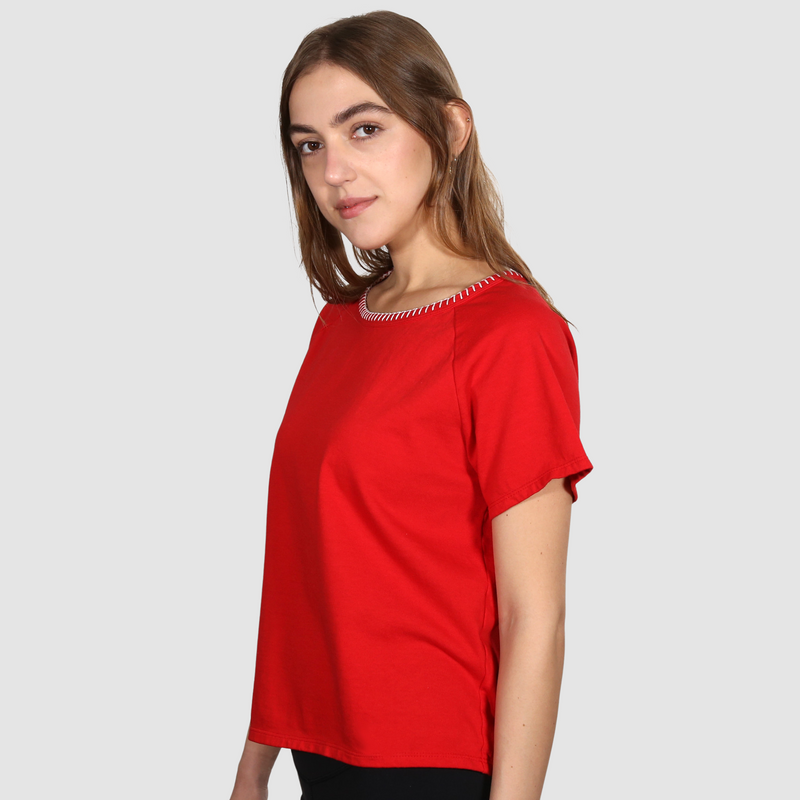 Woman wearing a red nautical themed  crew neck T Shirt on a white background