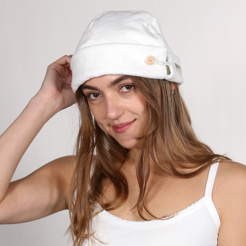 Woman wearing a white nautical themed beanie on a white background