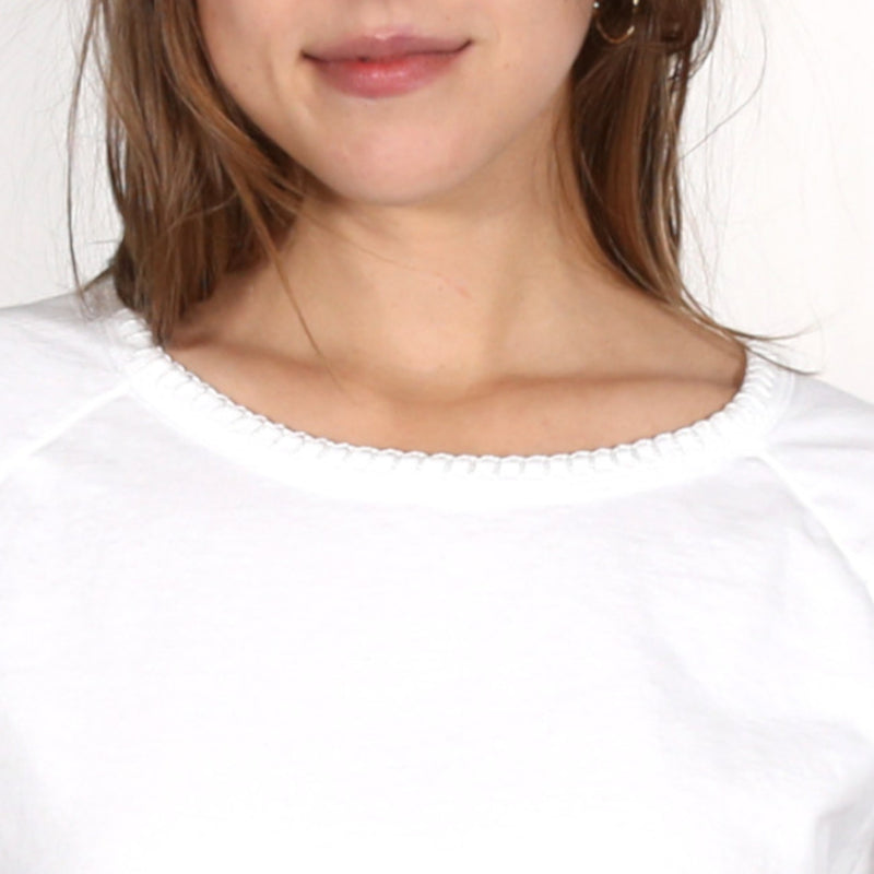 Close up of a woman wearing a white nautical themed crew neck T Shirt