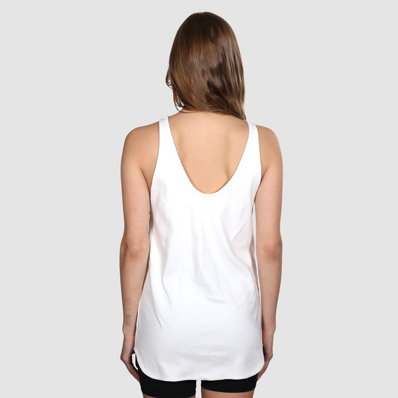 Woman facing away from camera wearing a white nautical themed tank top on a white background