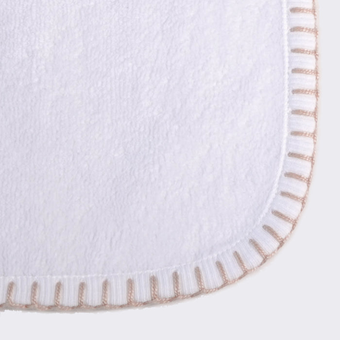 Close up of corner of a towel. White towel with desert sand color edge stiting.