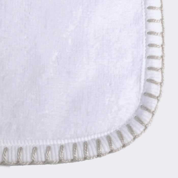 Close up of corner of a towel. White towel with Champagne color edge stiting.